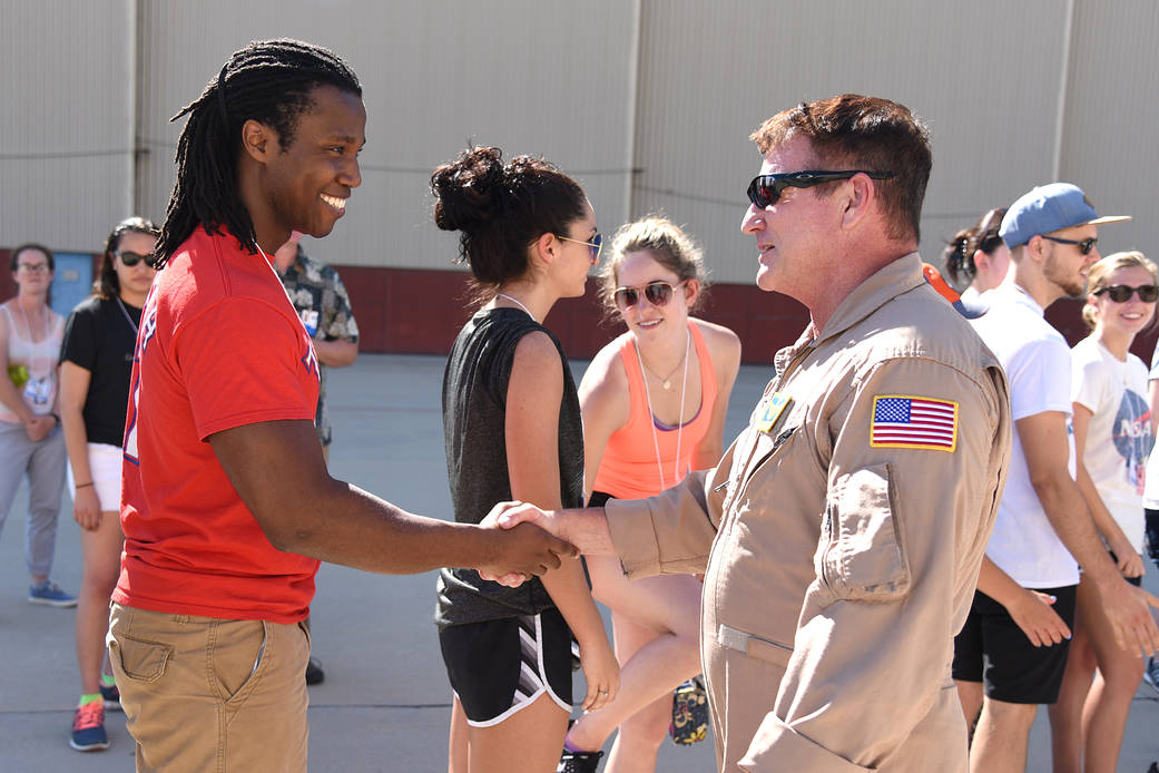 Student intern Fred Okafor shakes hands with NASA research pilot Alan Barringer.