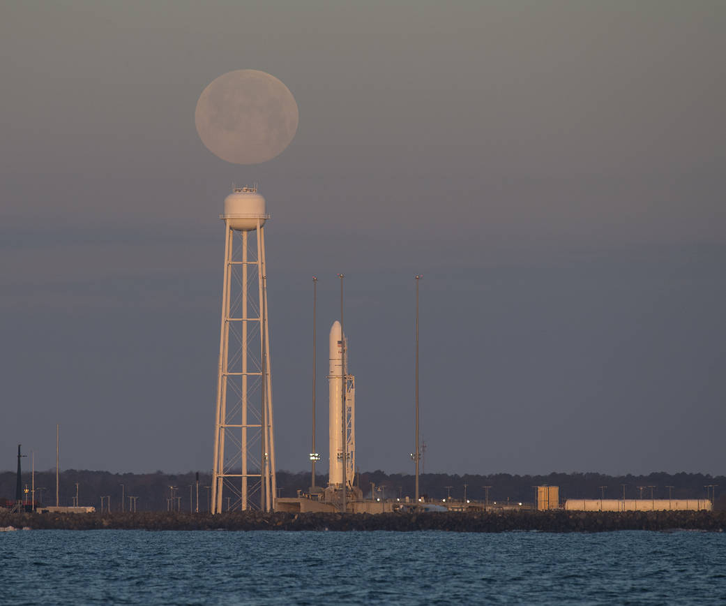 A Northrop Grumman Antares rocket carrying a Cygnus resupply spacecraft is seen at sunrise as the Moon sets Feb. 9, 2020.