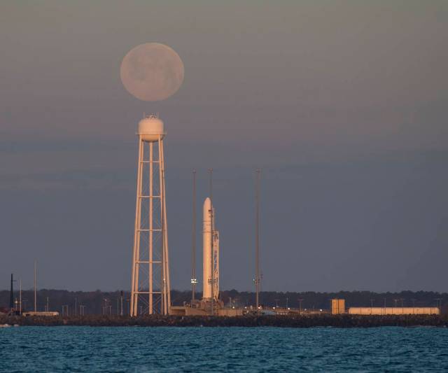 A Northrop Grumman Antares rocket carrying a Cygnus resupply spacecraft is seen at sunrise as the Moon sets Feb. 9, 2020.