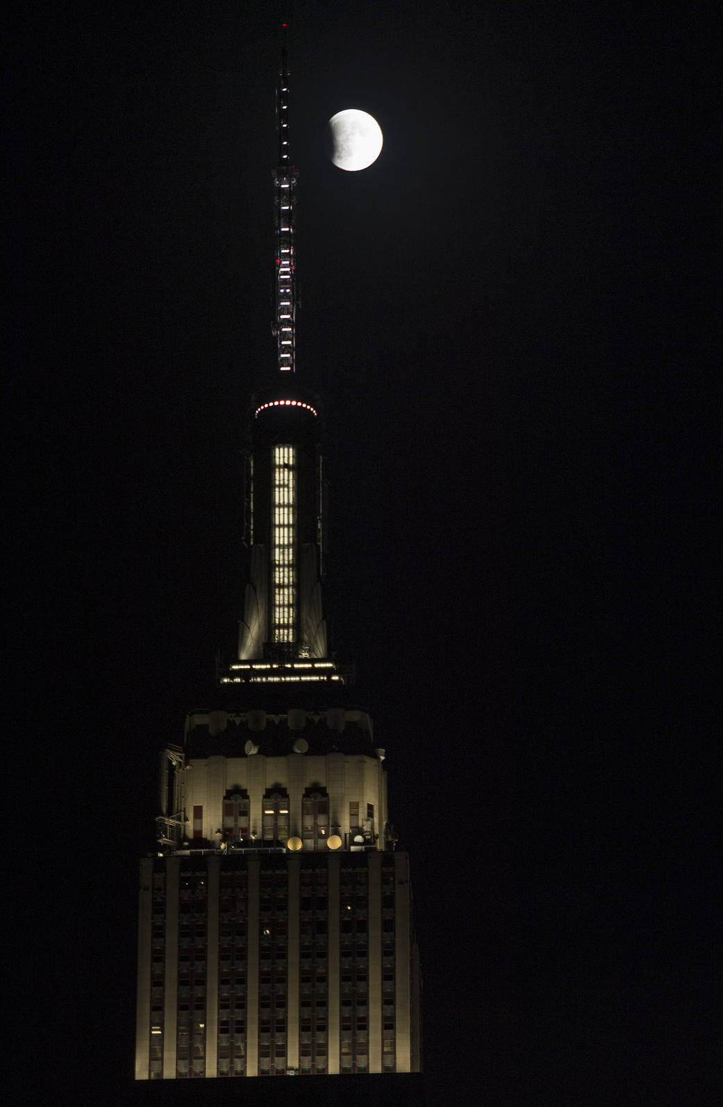 A perigee full moon, or supermoon, is seen next to the Empire State Building at the beginning of a total lunar eclipse, Sunday, 