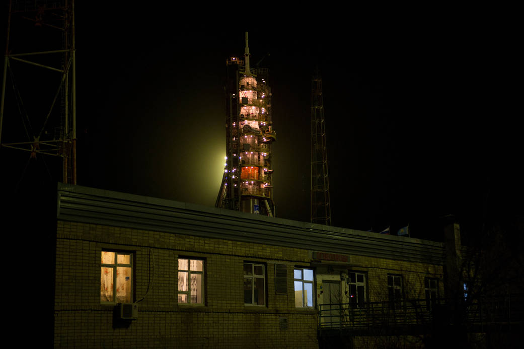 The Soyuz TMA-20M spacecraft surrounded by the gantry arms