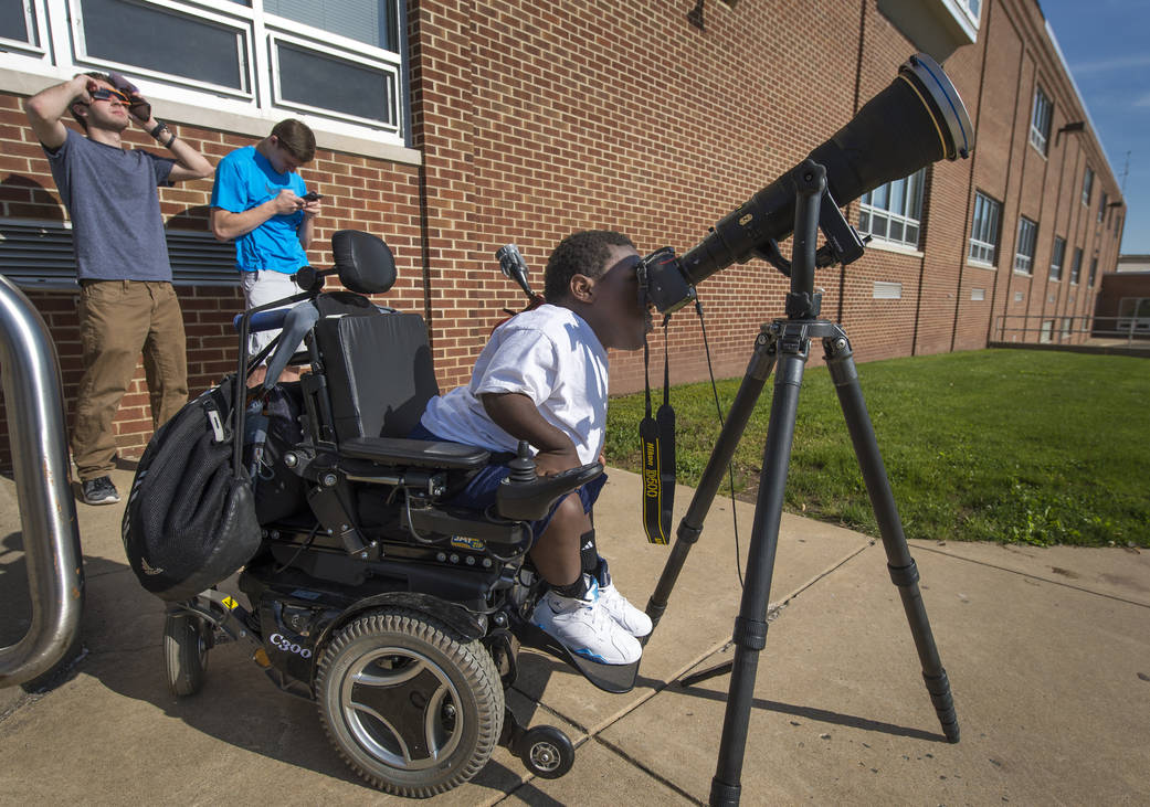 Boyertown Area High School 12th grade student Jay Hallman looks through a photographers lens and solar filter. 