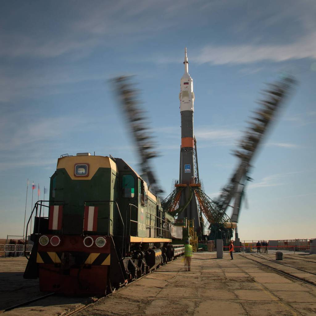 Gantry arms close around the Soyuz MS-10 rocket
