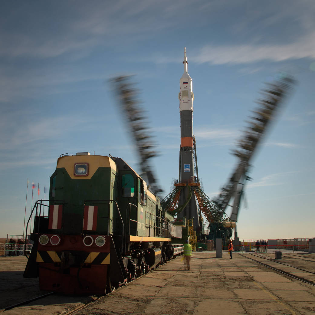 Gantry arms close around the Soyuz MS-10 rocket