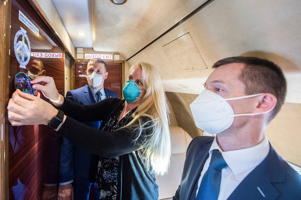 NASA astronaut Kate Rubins affixes a mission sticker inside an airplane