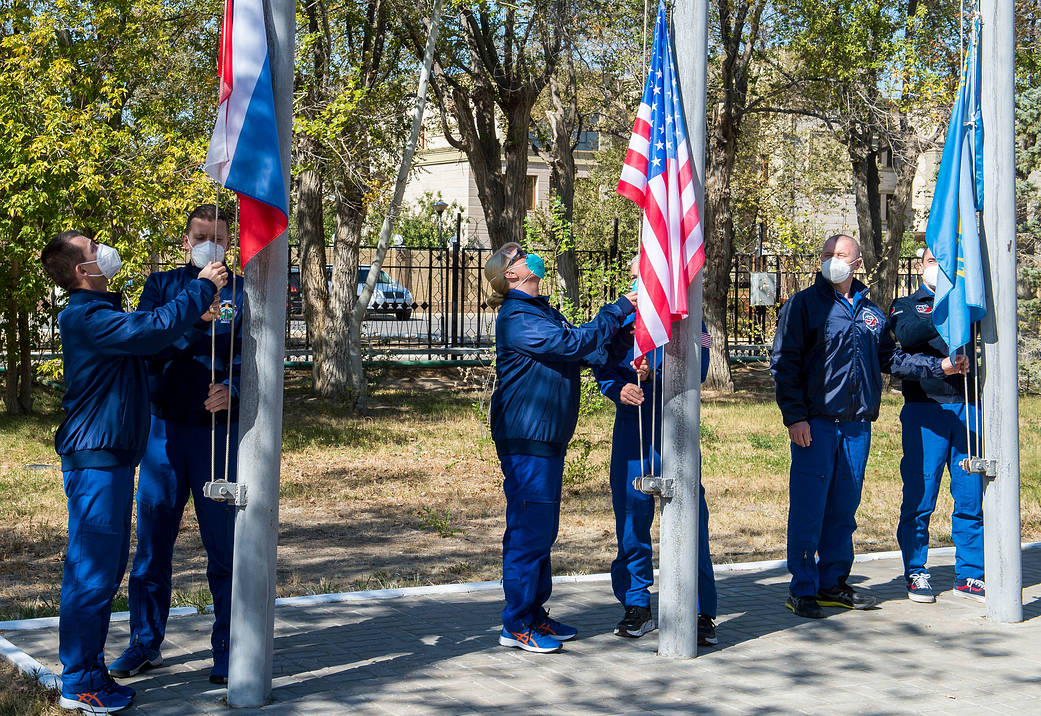 The Expedition 64 prime and backup crew members raise flags