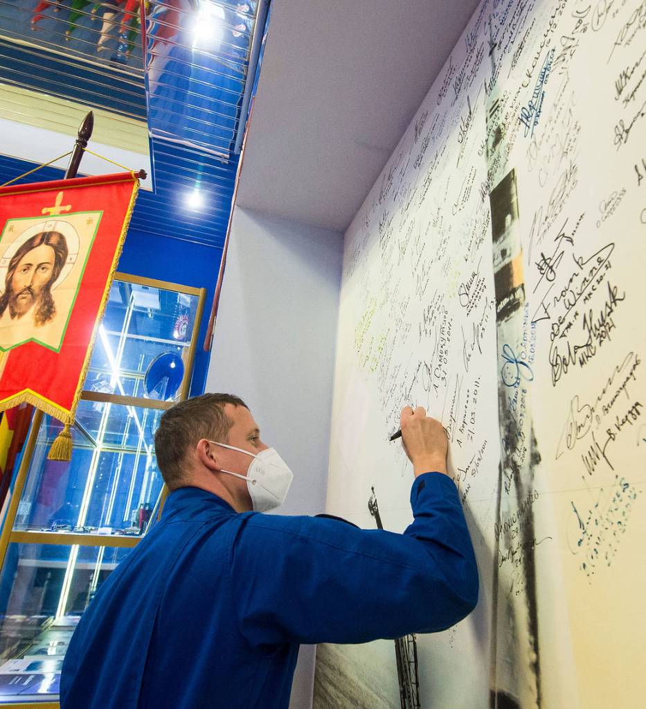 Cosmonaut Sergey Kud-Sverchkov signs a wall mural