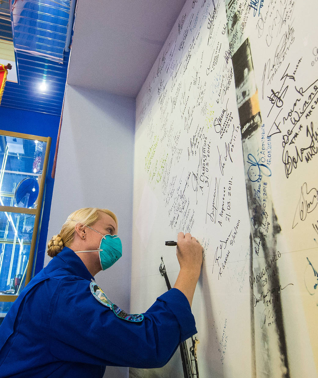 NASA astronaut Kate Rubins signs a wall mural