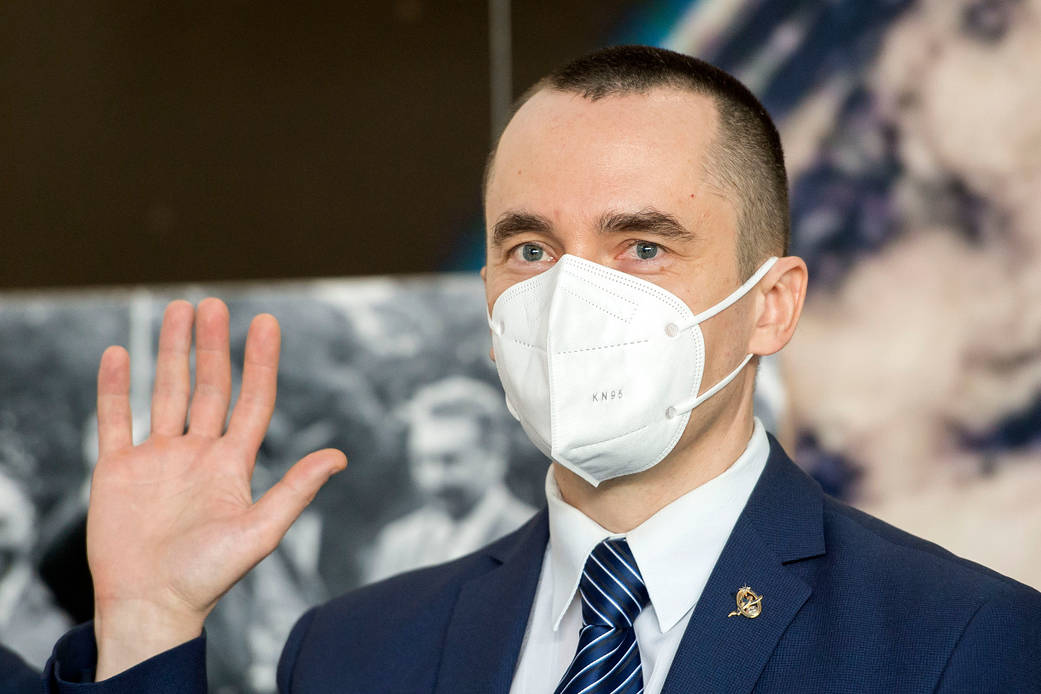 Cosmonaut Pyotr Dubrov of Roscosmos waves during a press conference