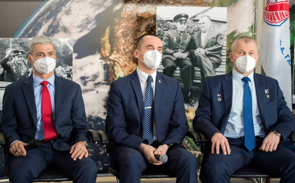 Expedition 65 crew members listen during a press conference