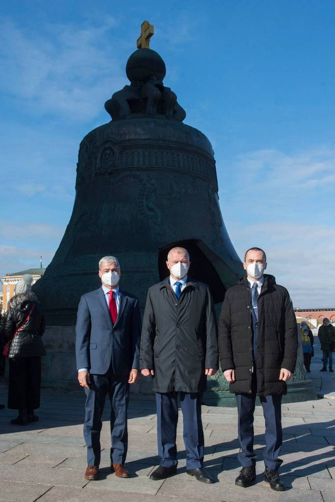 Expedition 65 prime crew members pose for a photo in front of the Tsar Bell