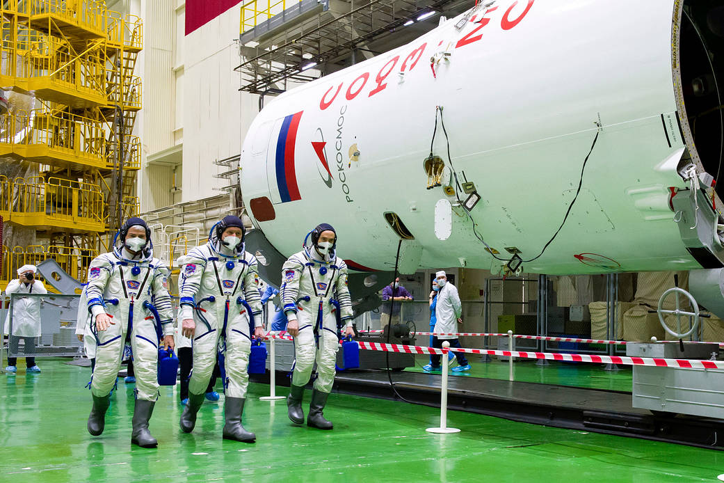 Expedition 65 prime crew members walk through Building 254