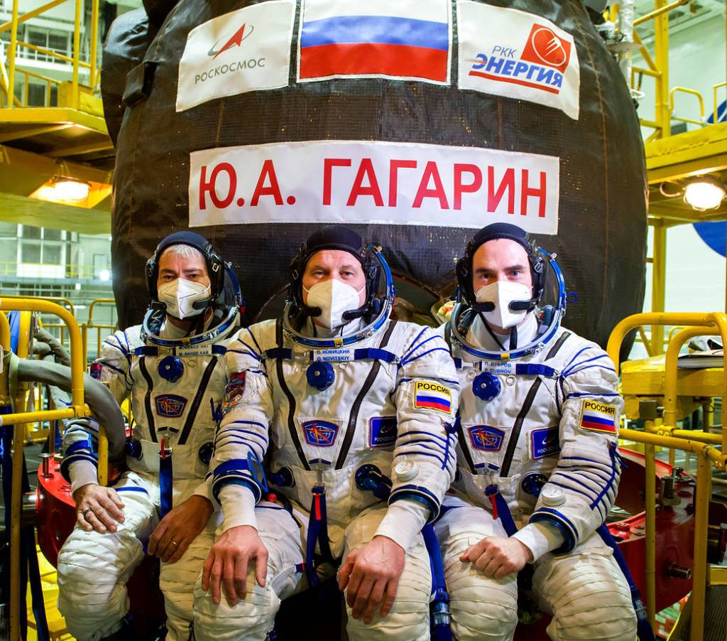 Expedition 65 prime crew members ose for a photo in front of the Soyuz