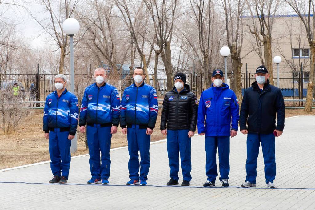 Expedition 65 prime and backup crew members just prior to raising flags