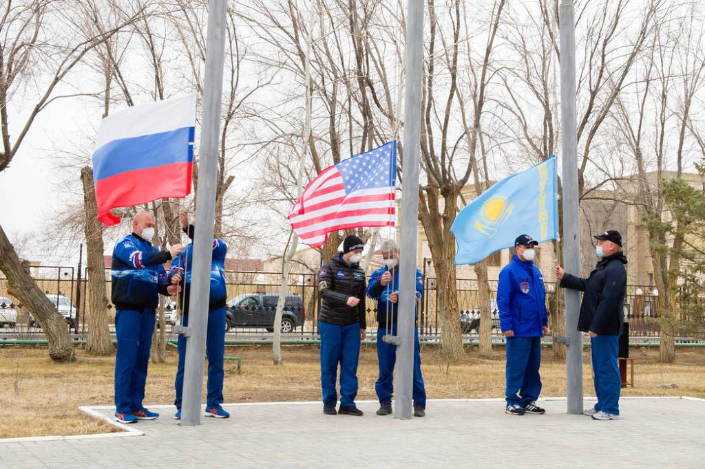 Expedition 65 prime and backup crew members raise the flags