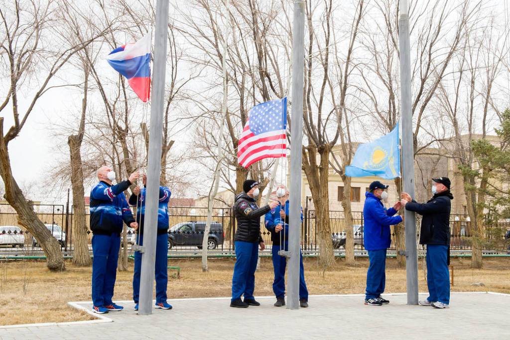 Expedition 65 prime and backup crew members raise the flags