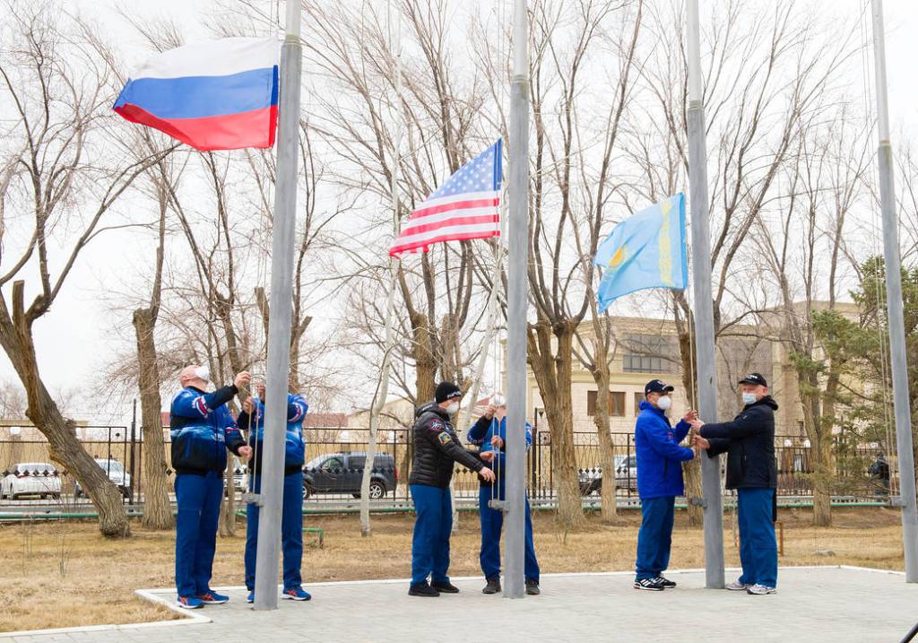 Expedition 65 prime and backup crew members raise flags