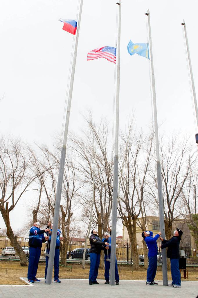 Expedition 65 prime and backup crew members raise flags