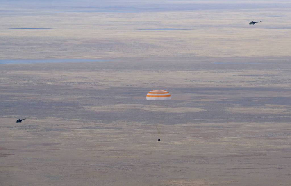 The Soyuz MS-19 crew ship parachutes to a landing