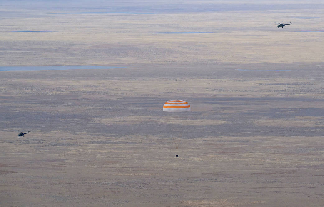 The Soyuz MS-19 crew ship parachutes to a landing