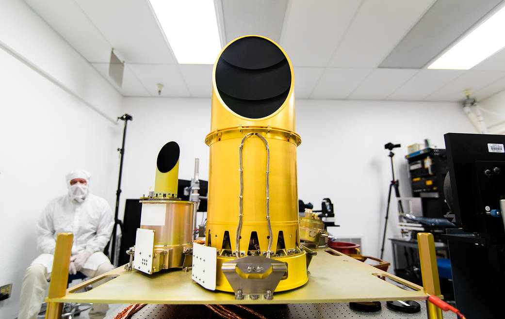 table with science instruments in gold, people