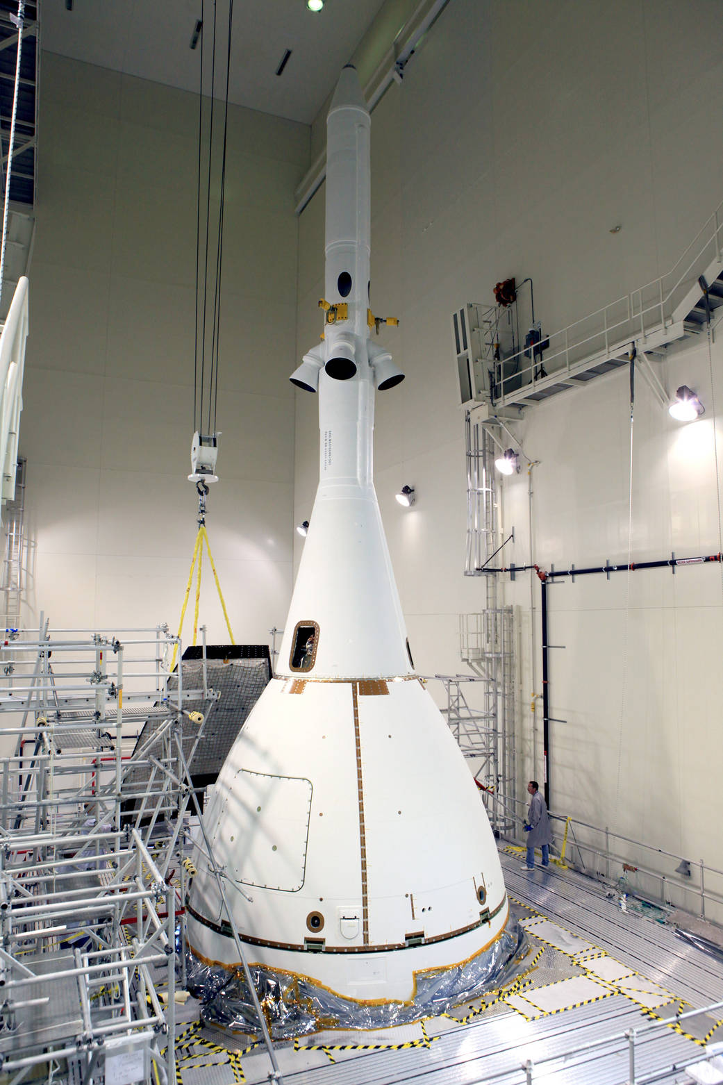 A crane brings the fourth and final Ogive panel closer for installation on Orion's Launch Abort System. 