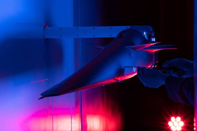 A technician works on the X-59 model during testing in the low-speed wind tunnel.