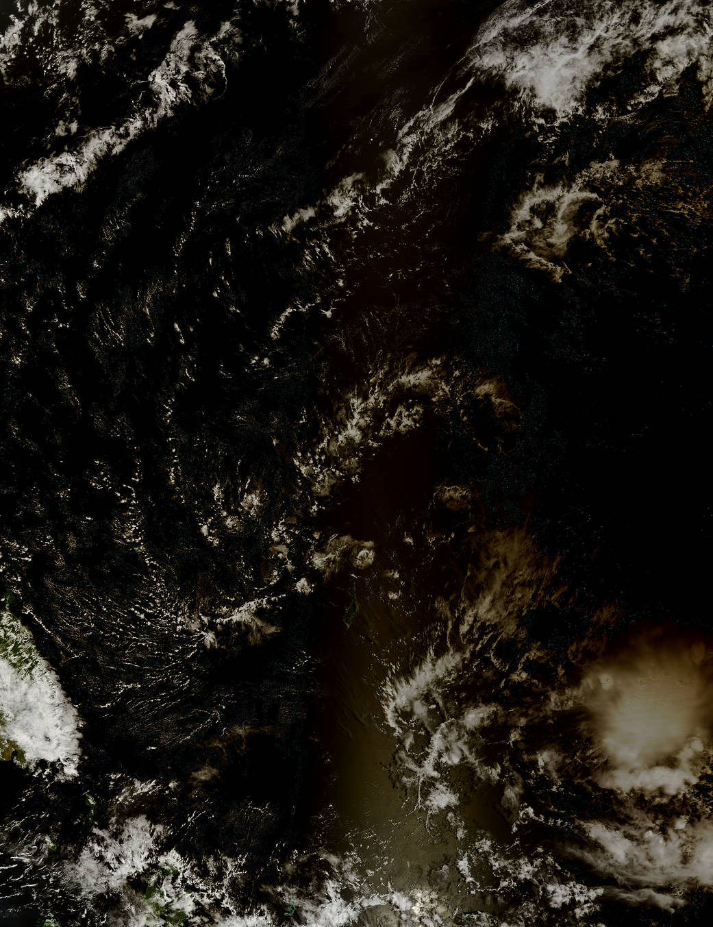 Clouds over ocean with darkening from pass of solar eclipse at lower right