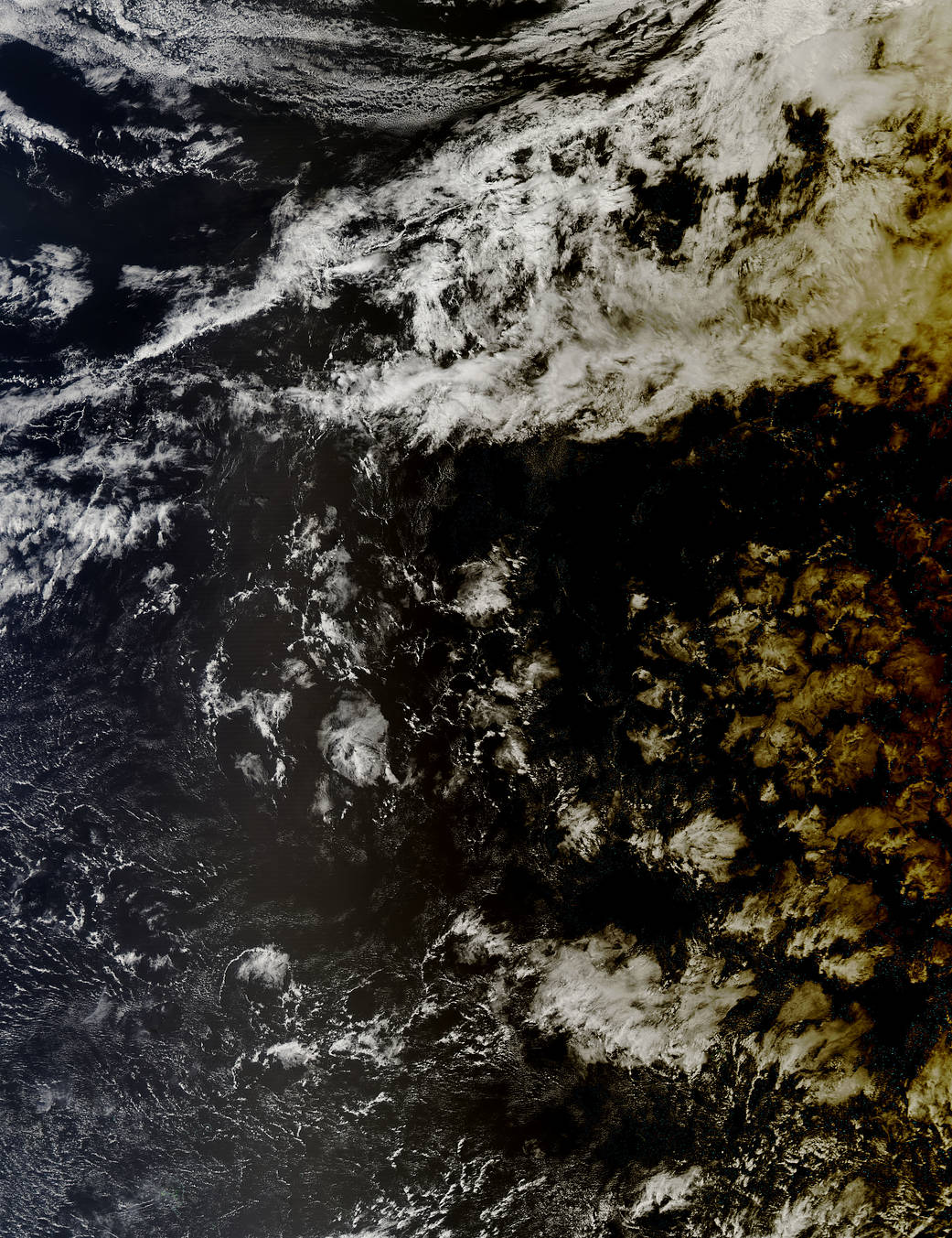Clouds over the ocean gradually shaded darker at right as solar eclipse begins to move across