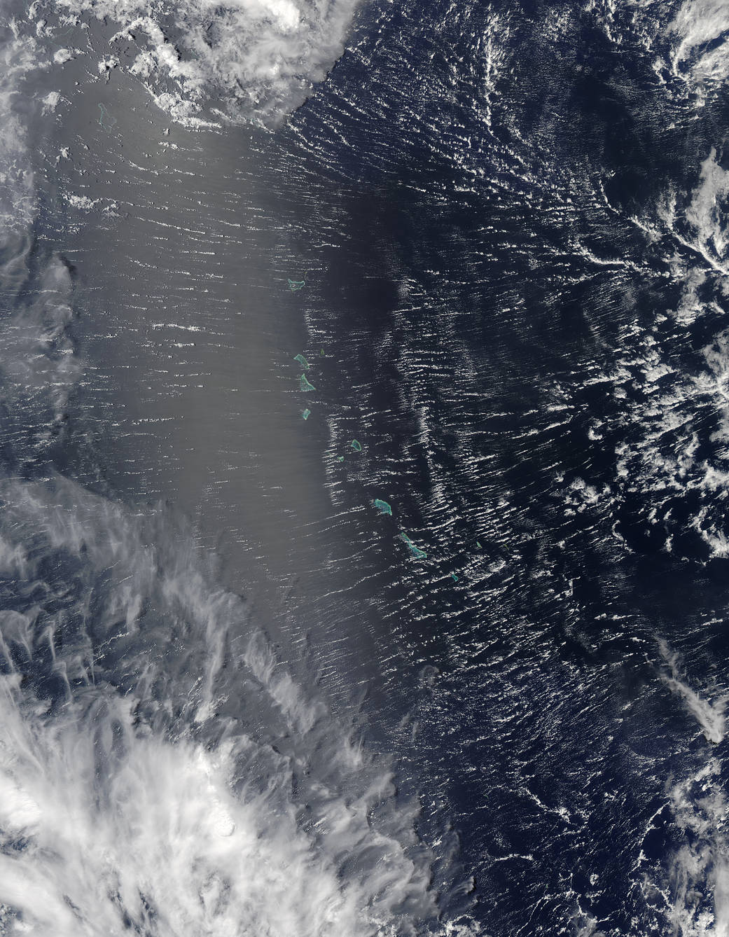 Satellite view of clouds and sunglint over islands in the Pacific Ocean