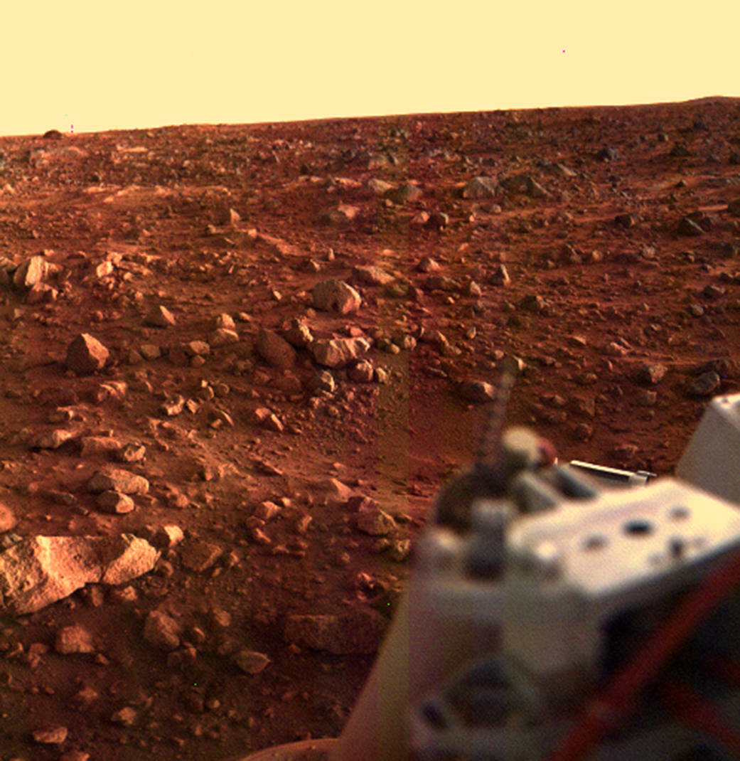 Color image of rocky Martian surface with portion of Viking Lander in lower right corner
