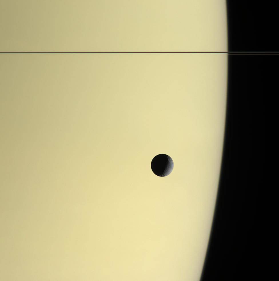 Tethys floats before the massive, golden-hued globe of Saturn