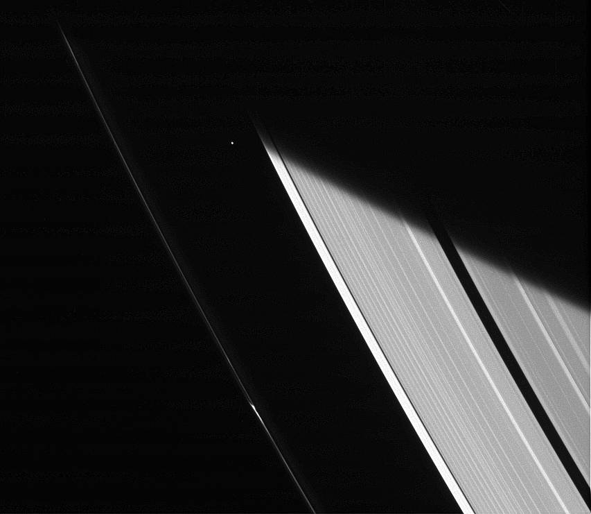 The Cassini spacecraft captures a glimpse of the moon Atlas shortly after emerging from Saturn's shadow