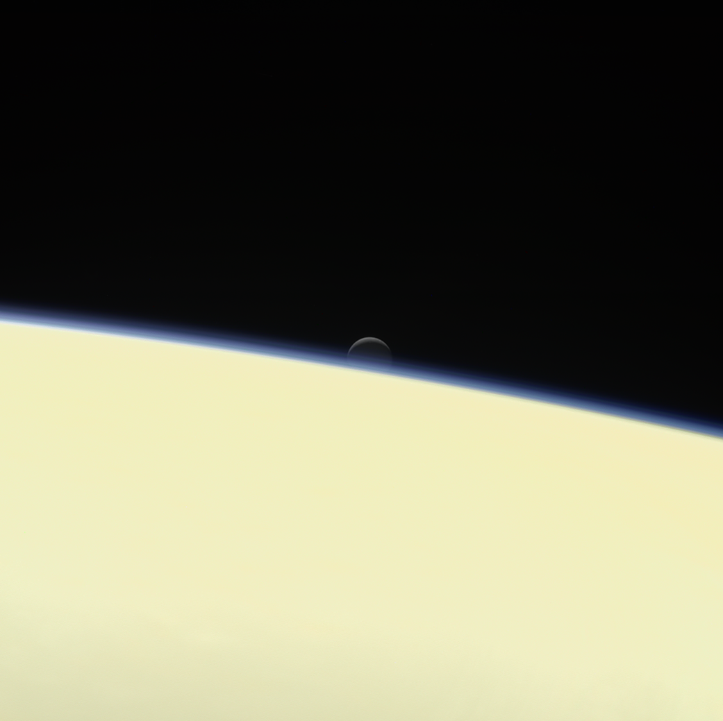 moon Enceladus behind Saturn