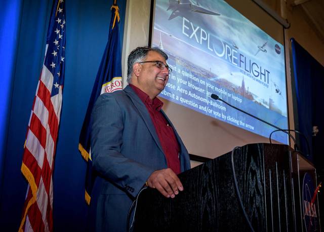 Parimal Kopardekar at a podium with American and NASA flags behind and an onscreen graphic that reads "Explore Flight."