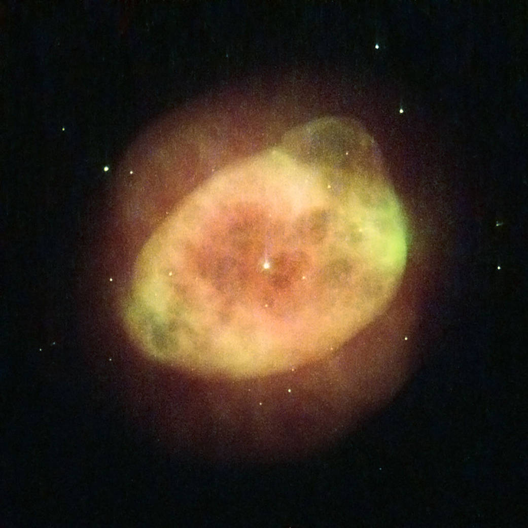 large, yellow-orange gas cloud, with smaller, brighter cloud inside and single bright star in the center