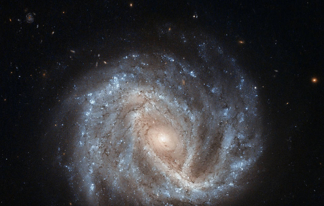 spiral galaxy with brightest spot at center and arms extending out into deep space