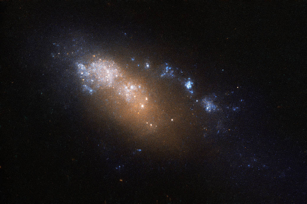 an orange-white smear of stars trailing blue-white spots