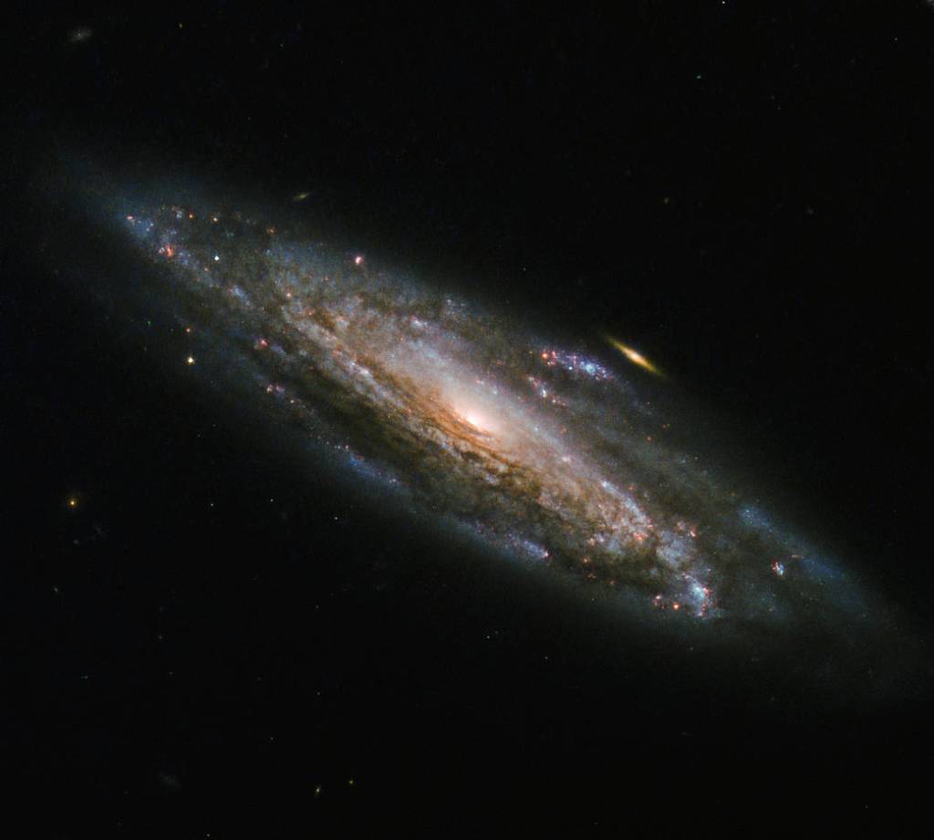 spiral galaxy with small golden galaxy in background