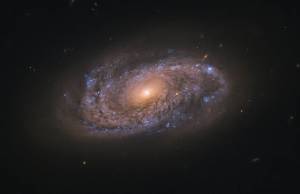 swirling spiral galaxy named NGC 2906, as seen by Hubble