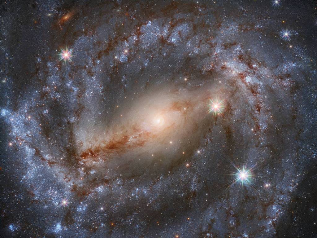 spiral galaxy NGC 5643 with a bright, barred center and vaguely purplish swirling arms