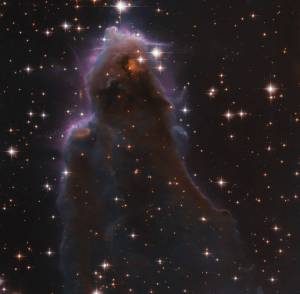 whisp-like, purple-hued view of star-forming region J025157.5+600606 against black backdrop of space, as seen by Hubble