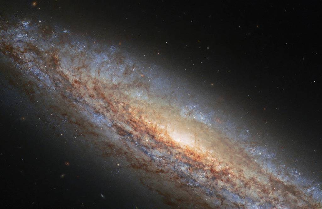 NGC 4666, a spiral galaxy, takes center stage in this image from the NASA/ESA Hubble Space Telescope. 