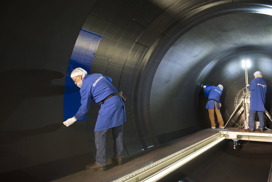 An Orbital ATK employee installs insulation to the rear segment for the second booster qualification test.