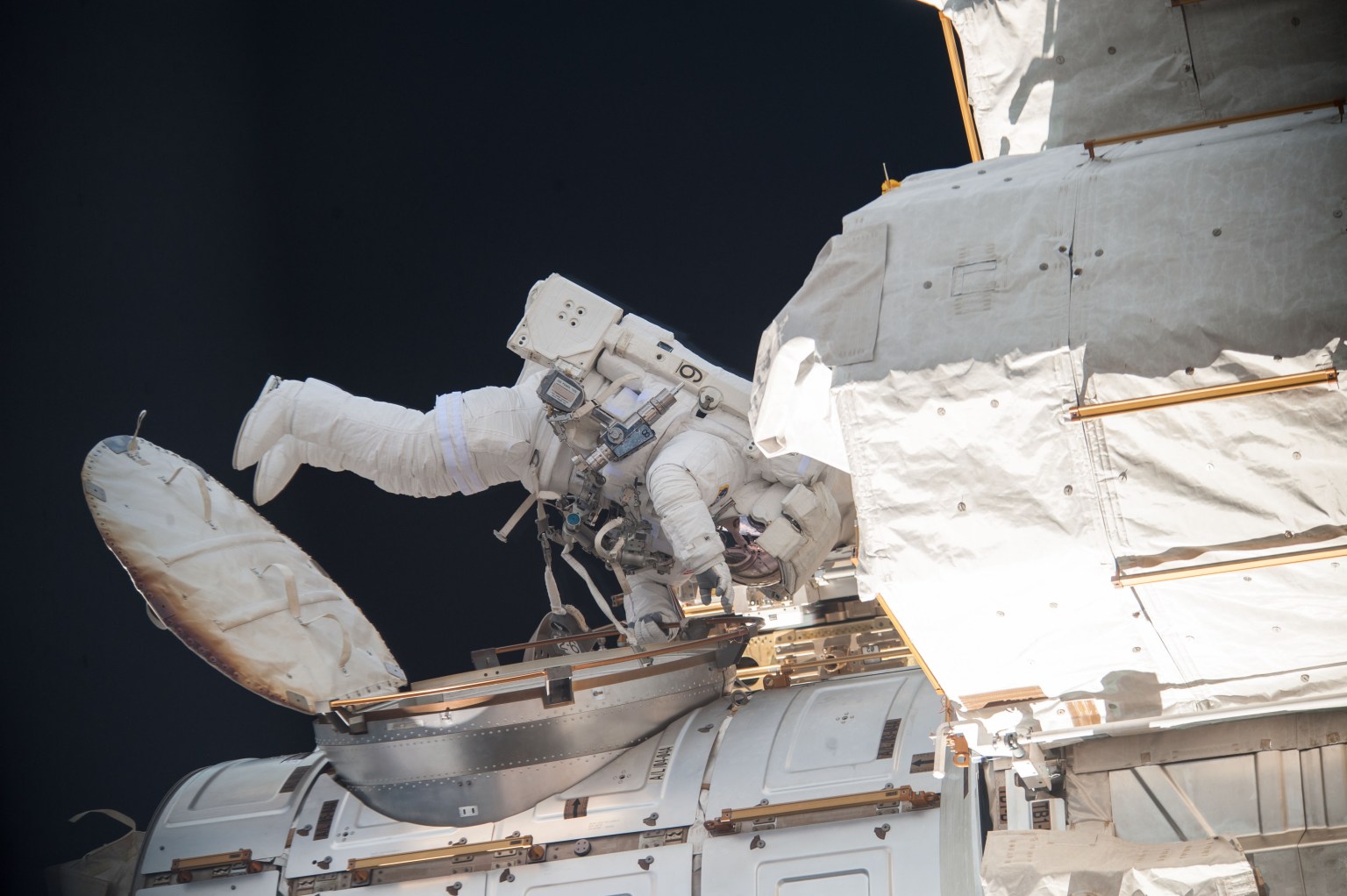 Seen near the hatch to the Quest airlock, NASA astronaut Mike Hopkins participates in the first Expedition 38 spacewalk designed to troubleshoot a faulty coolant pump on the International Space Station. He was joined by NASA astronaut Rick Mastracchio while four crewmates representing Roscosmos and the Japan Aerospace Exploration Agency remained inside the orbital outpost.