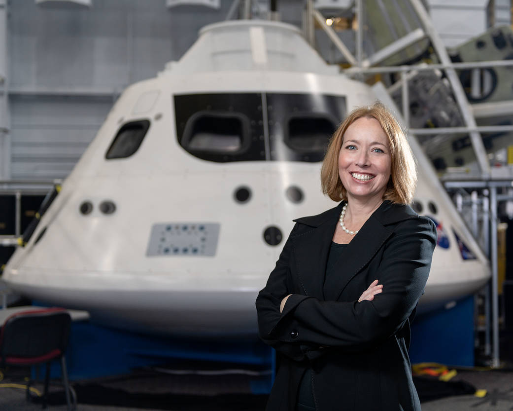 Exploration Integration and Science Associate Director Rebekah Reed standing in front of a model of the Orion spacecraft in the Mockup Facility.