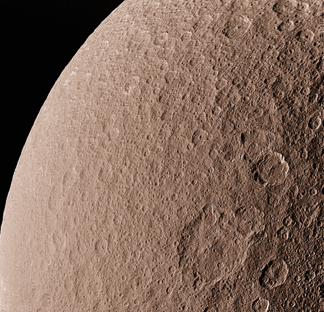 Closeup of moon Rhea taken from spacecraft showing moon's cratered surface