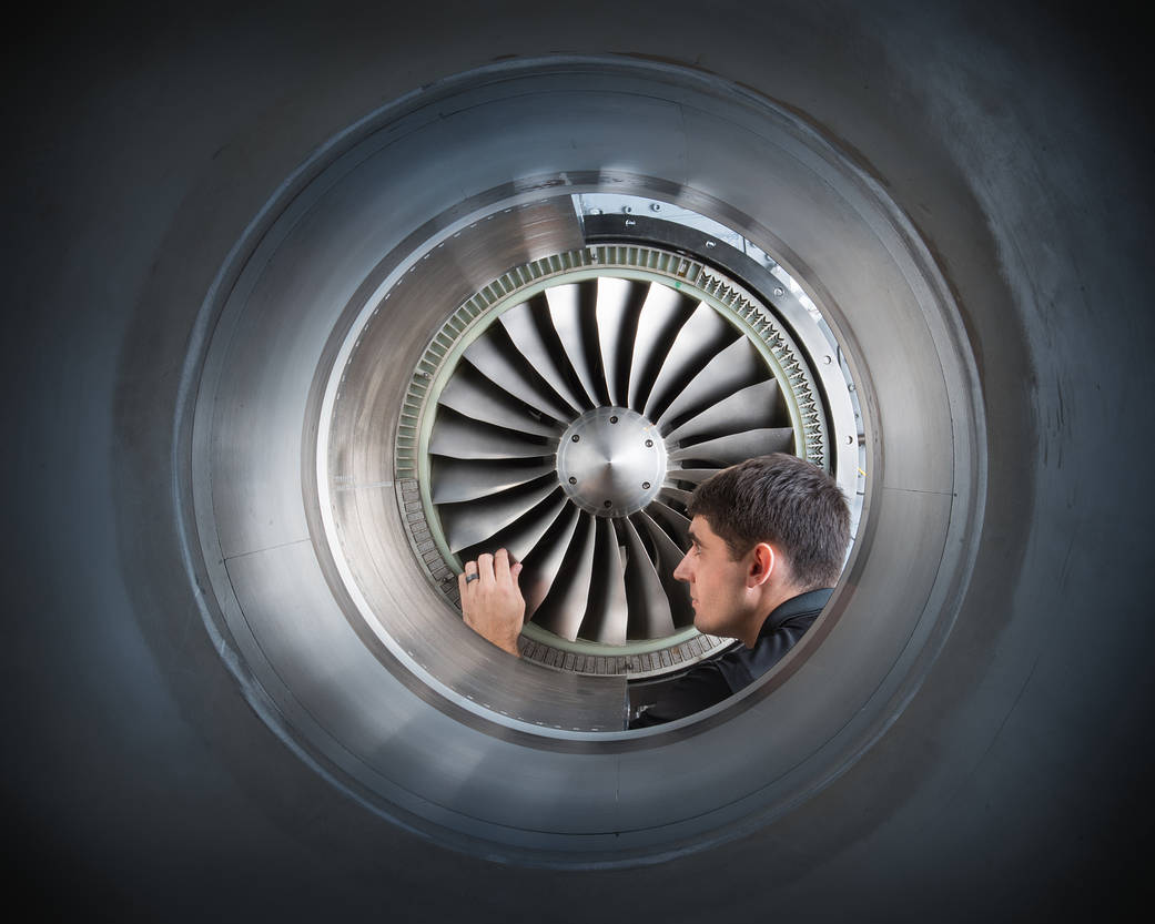A researcher inspecting the fan blade tips on a rotor.