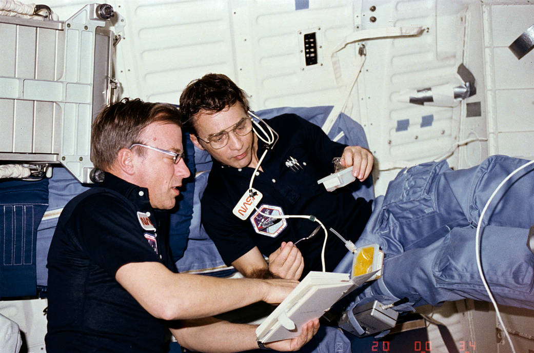 Astronauts look at crew activity plan aboard space shuttle