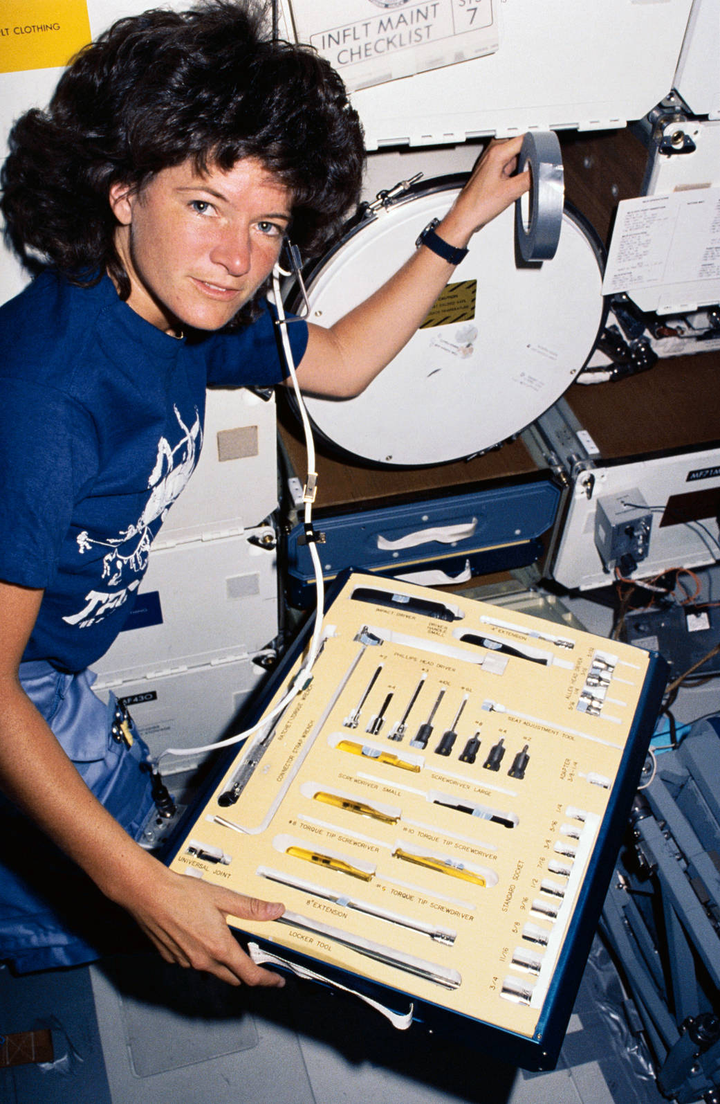 Astronaut Sally Ride holding toolkit during the STS-7 mission aboard shuttle Challenger